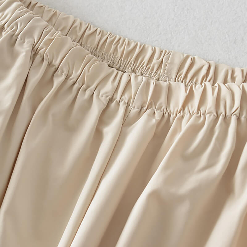 Close-up of beige oversized baggy high-waisted sweatpants for women, featuring an elastic waist and woven polyester fabric.